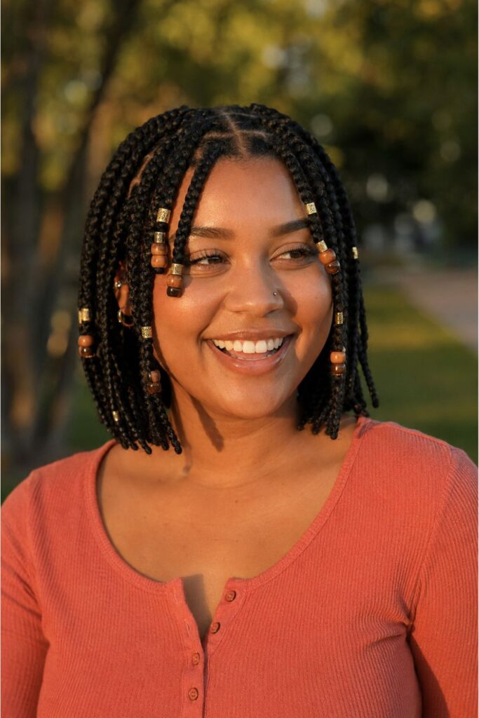 Woman with a braided bob with beads featuring lightweight wooden and gold bead accents