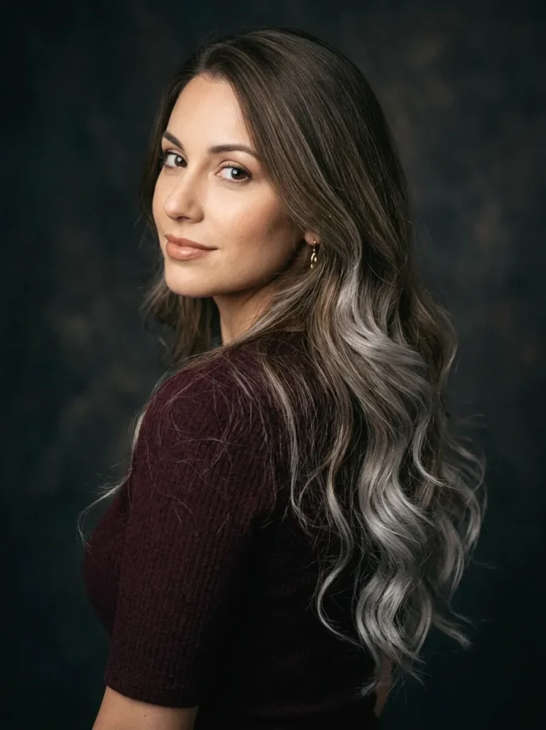 Woman with brown layered hair and melted silver ends showing seamless ombre color transition