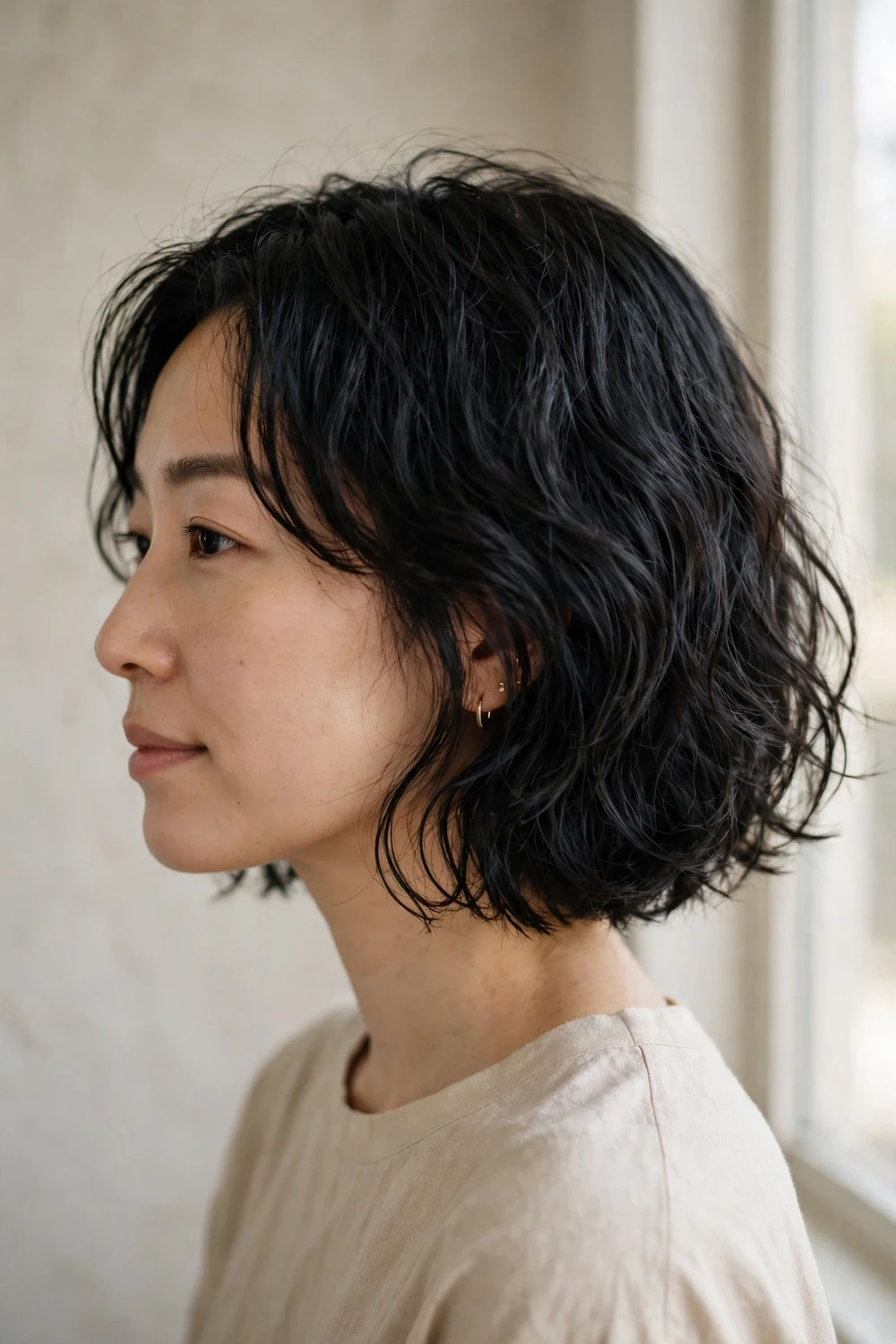 Air-dried natural wavy bob on black chin-length hair, side view