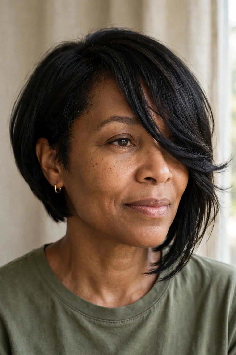 Black woman with asymmetrical bob and long side-swept bangs blending into the longer side