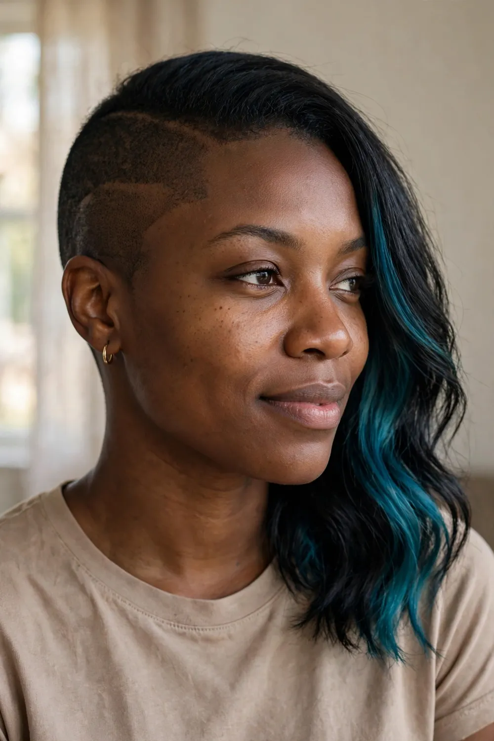 Two-tone bob with one shaved side and teal blue color panel on black hair