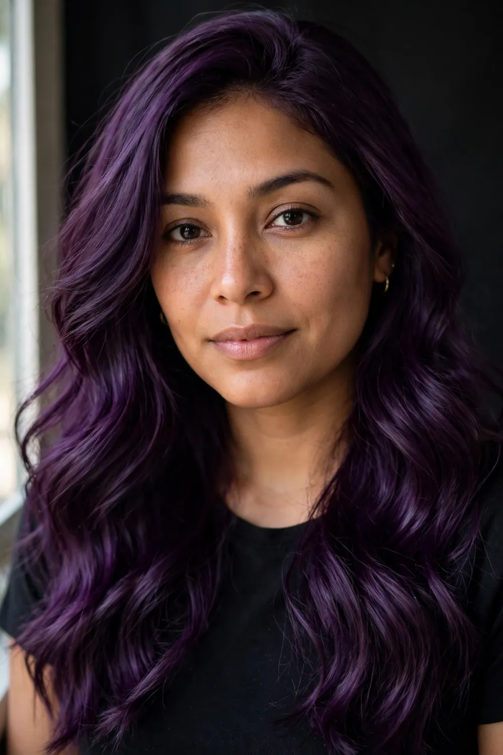 Woman with medium skin tone and deep purple hair in soft waves