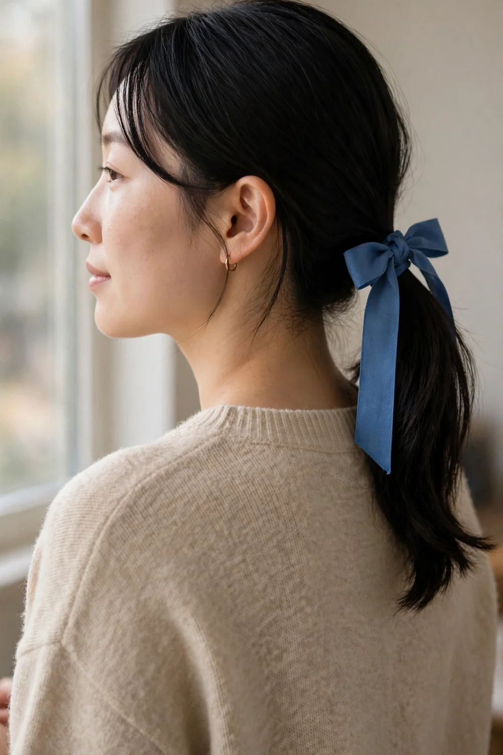 Simple low ponytail tied with a blue ribbon bow
