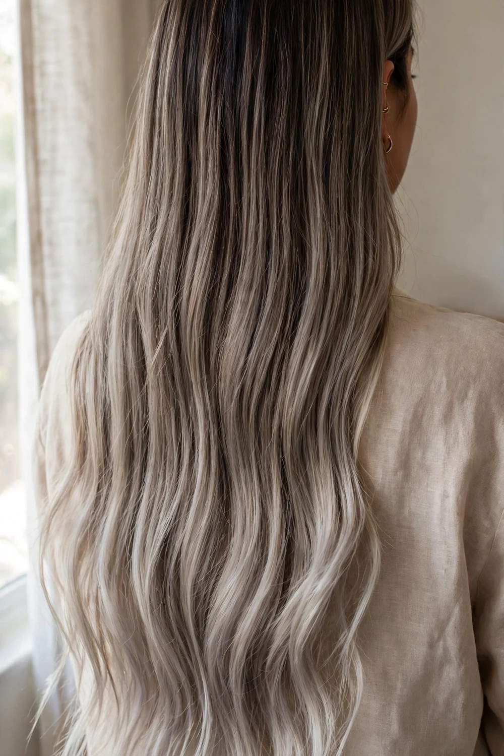 Long hair with smoky ash blonde melt from dark roots to lighter ends