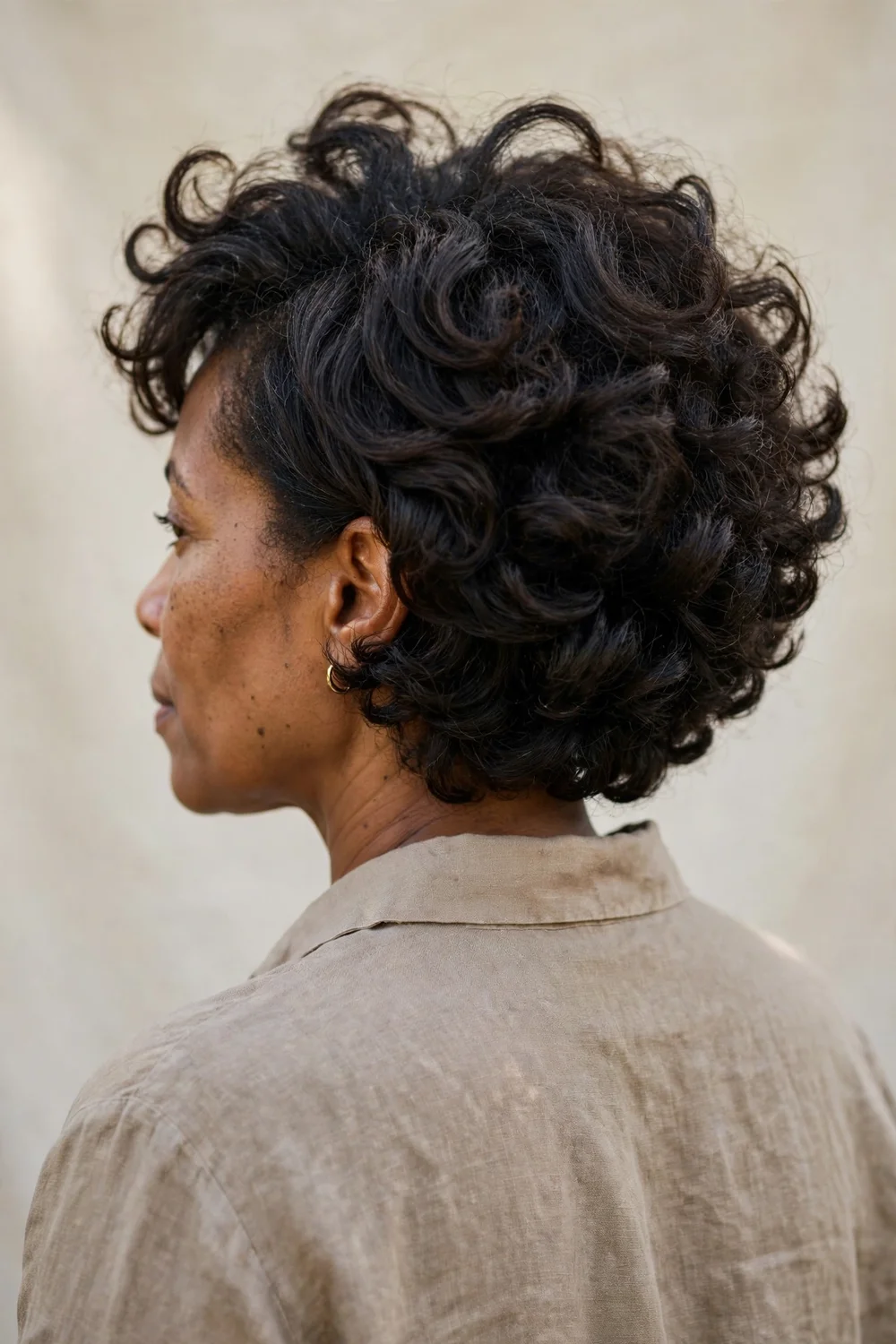 Woman with stacked curly bob haircut showing volume at the back