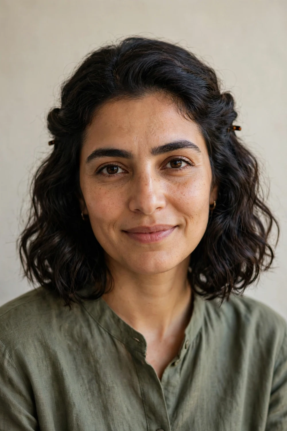 Middle Eastern woman with a dark wavy bob styled in a half-up twist