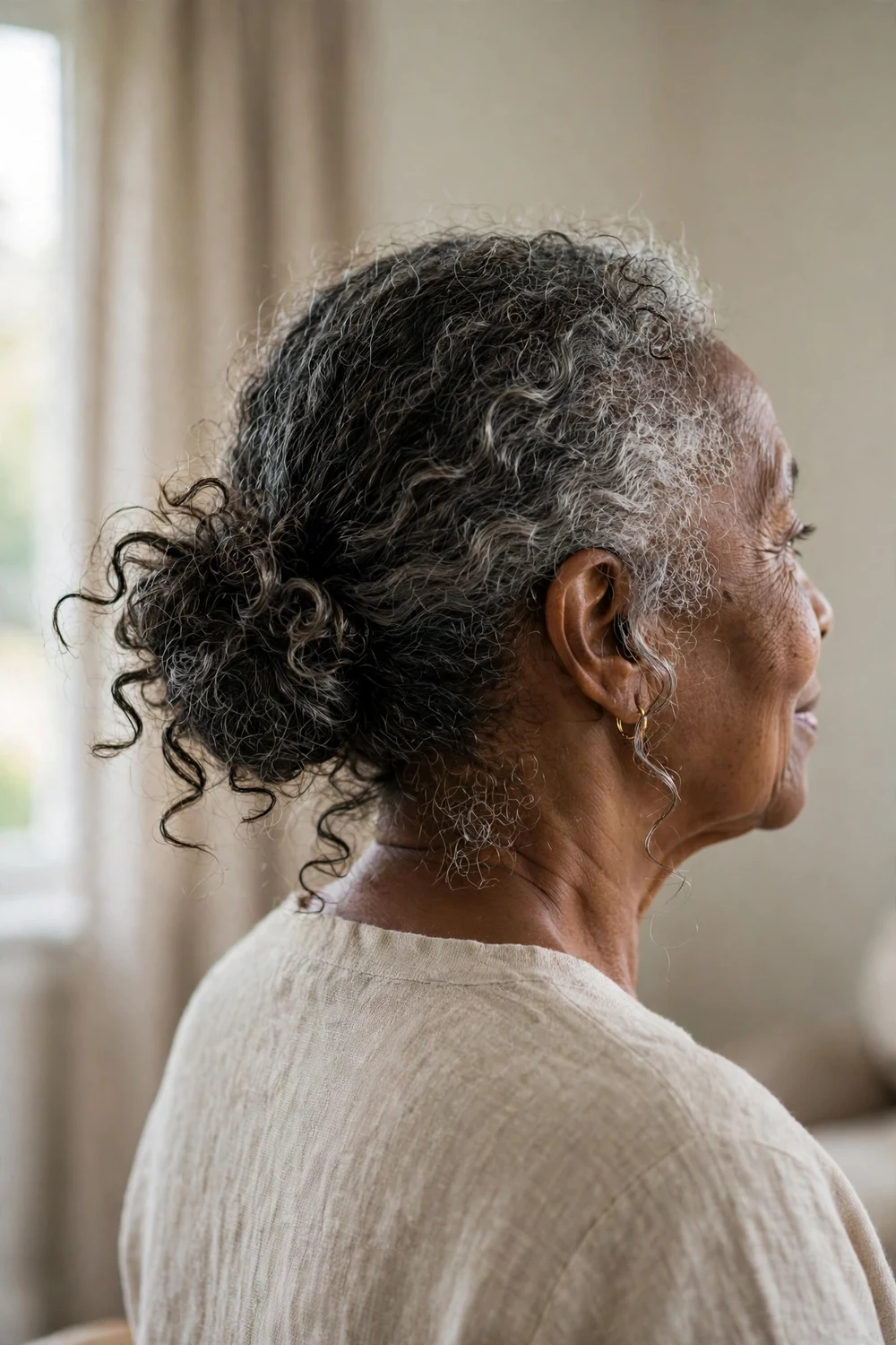 Older Black woman with a messy curly bun