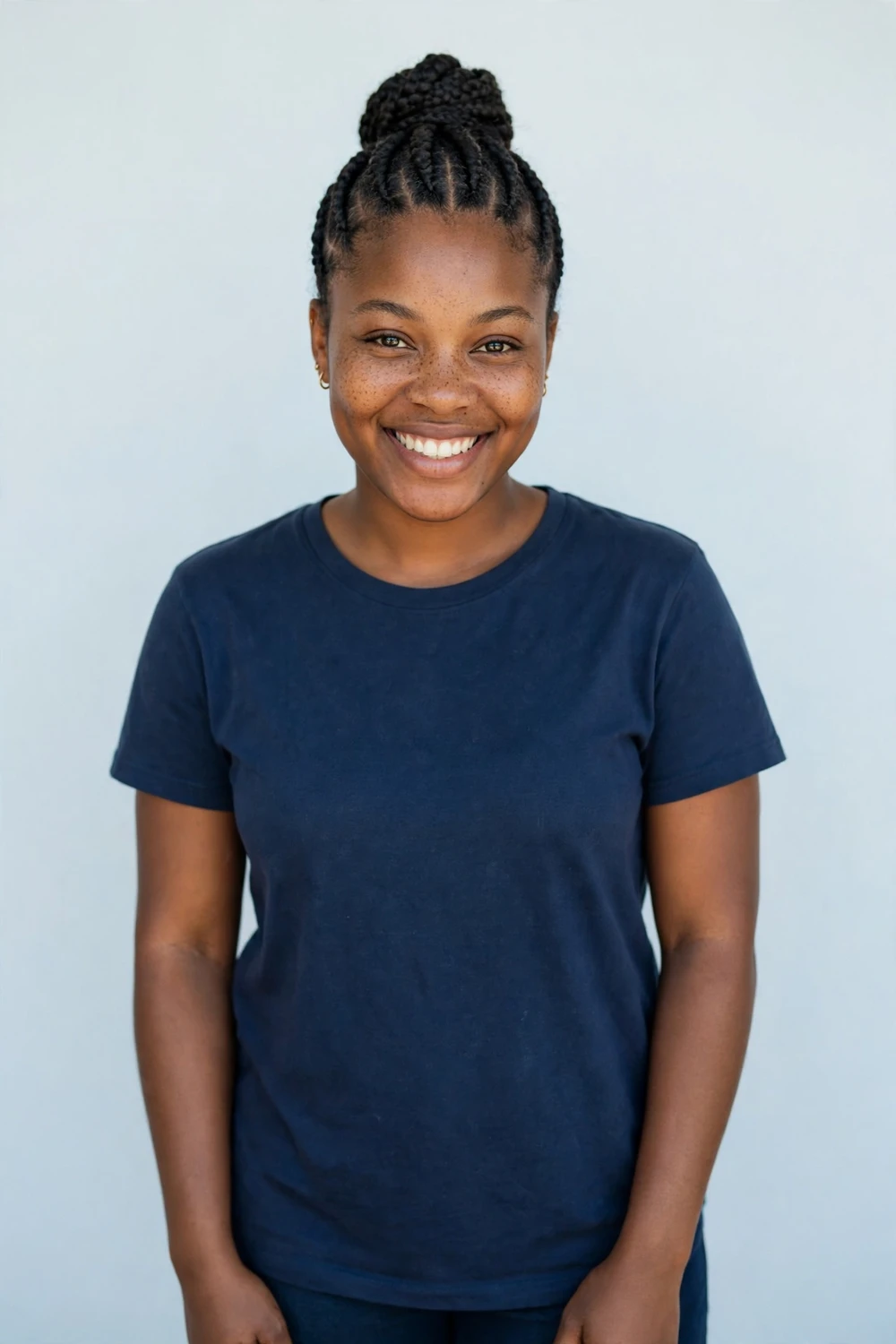 Natural cornrows gathered into a high bun updo on a Black woman