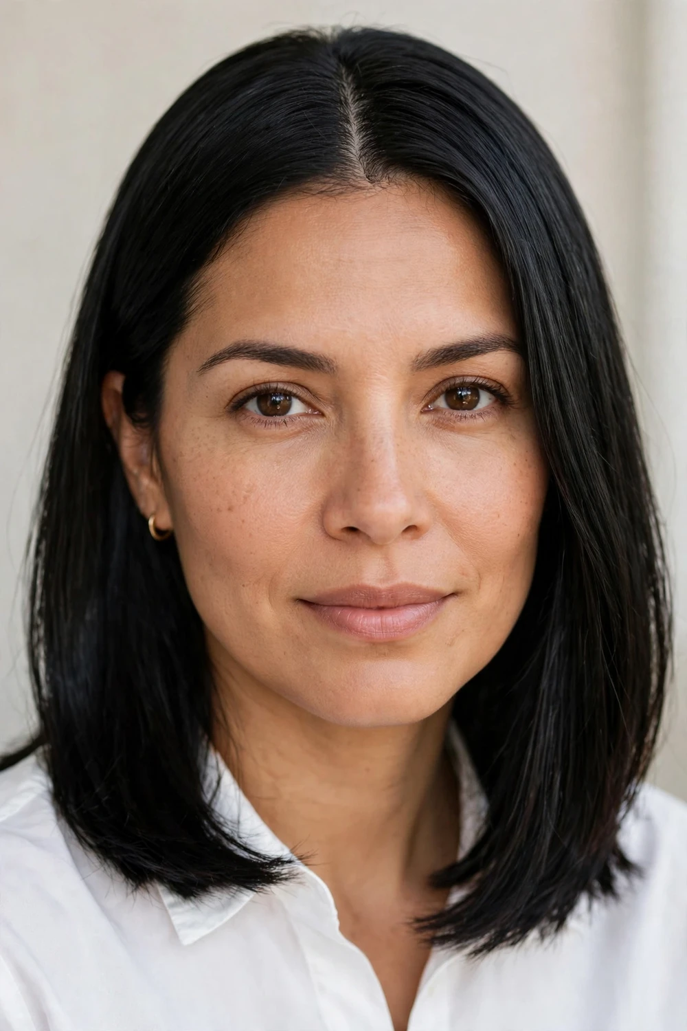 Oval-faced woman with a sleek straight shoulder-length haircut