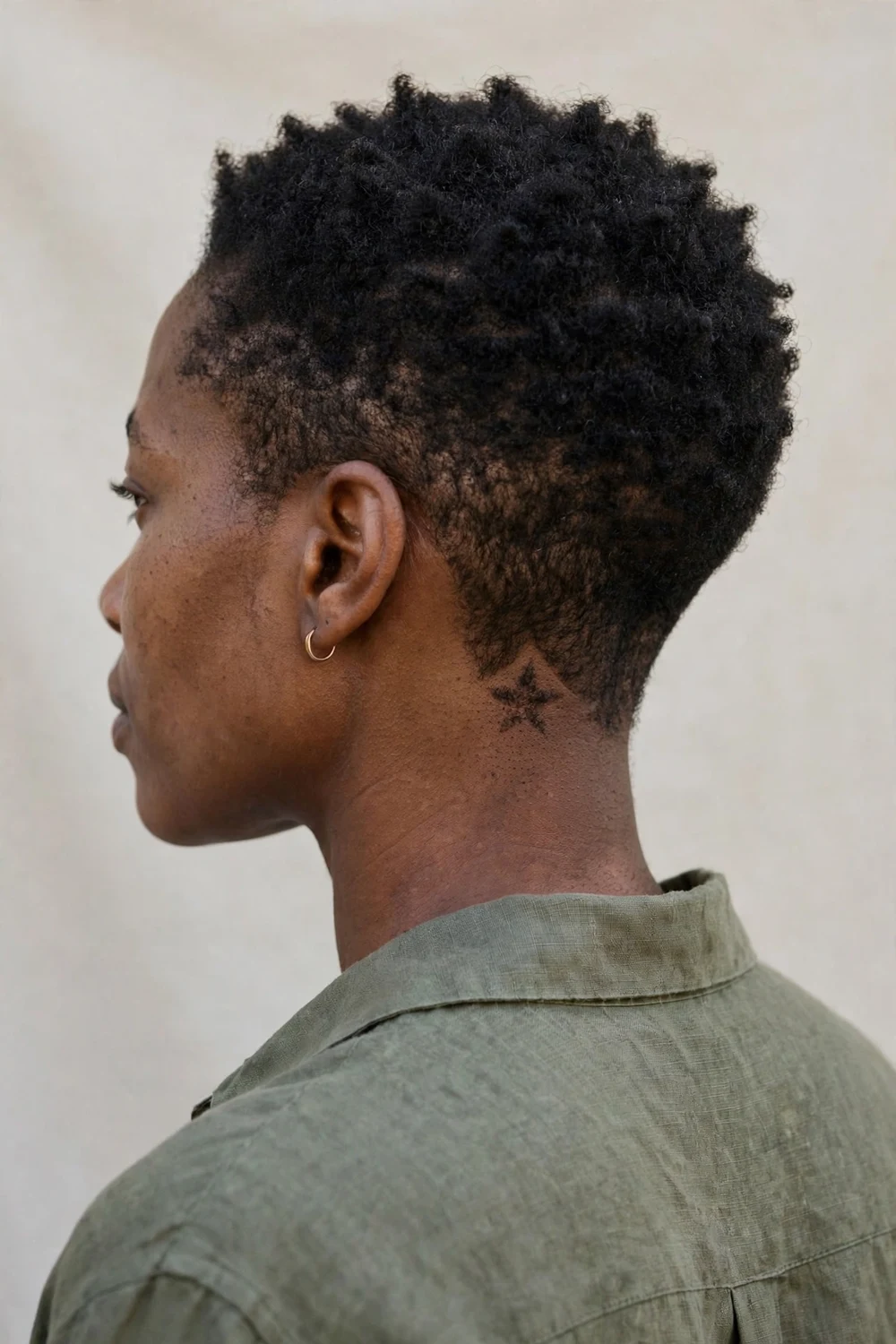 Black woman with a tapered low cut and a small star design shaved at the nape