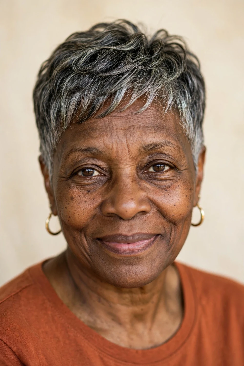 Black woman in her early 60s with a tapered pixie cut in salt-and-pepper hair