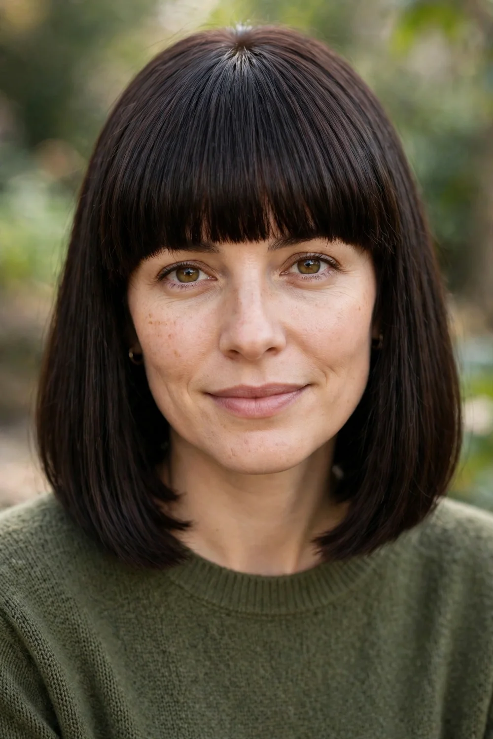 Woman with a blunt haircut and thick straight bangs