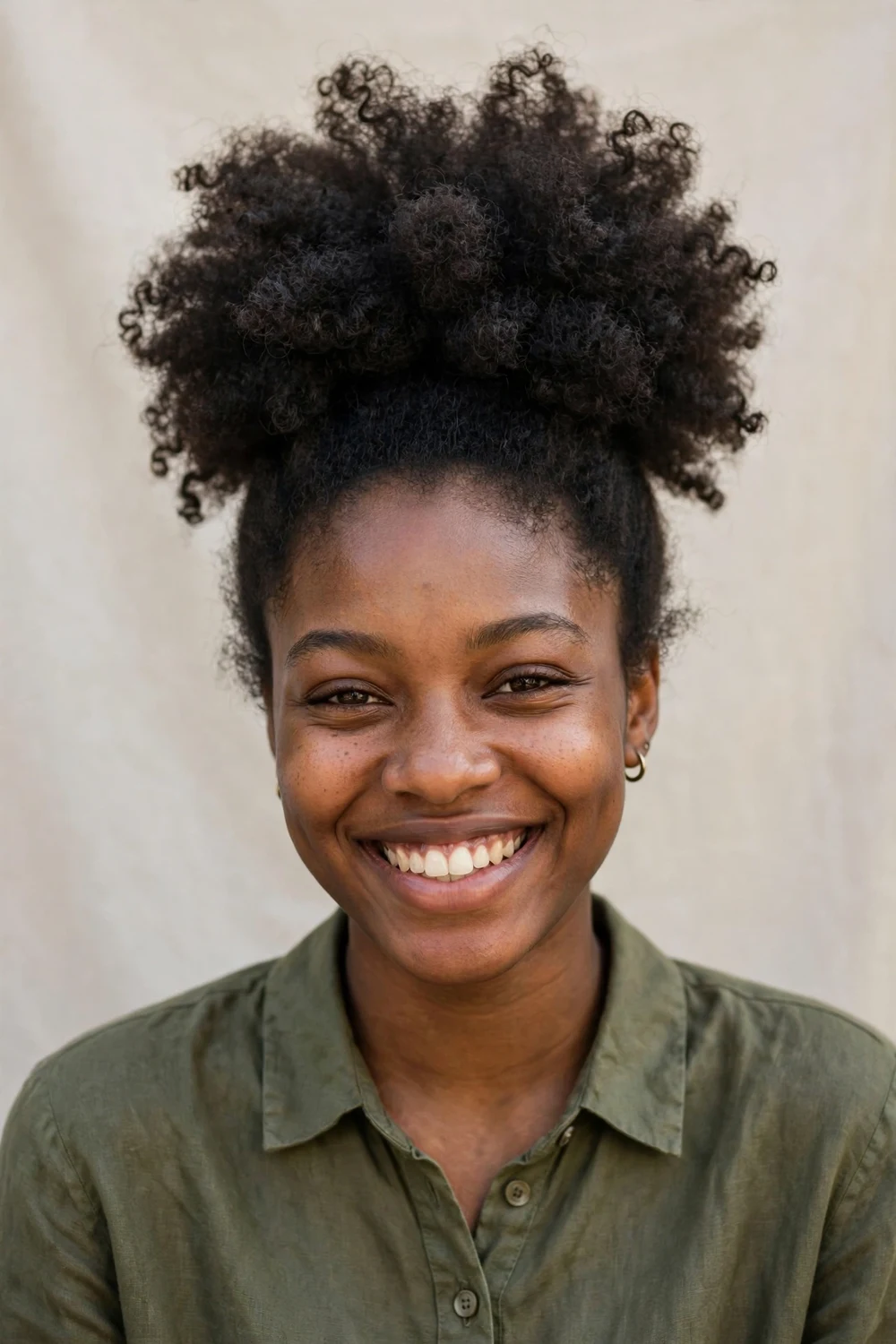 Black woman with a twist-out pineapple updo of defined curls on top