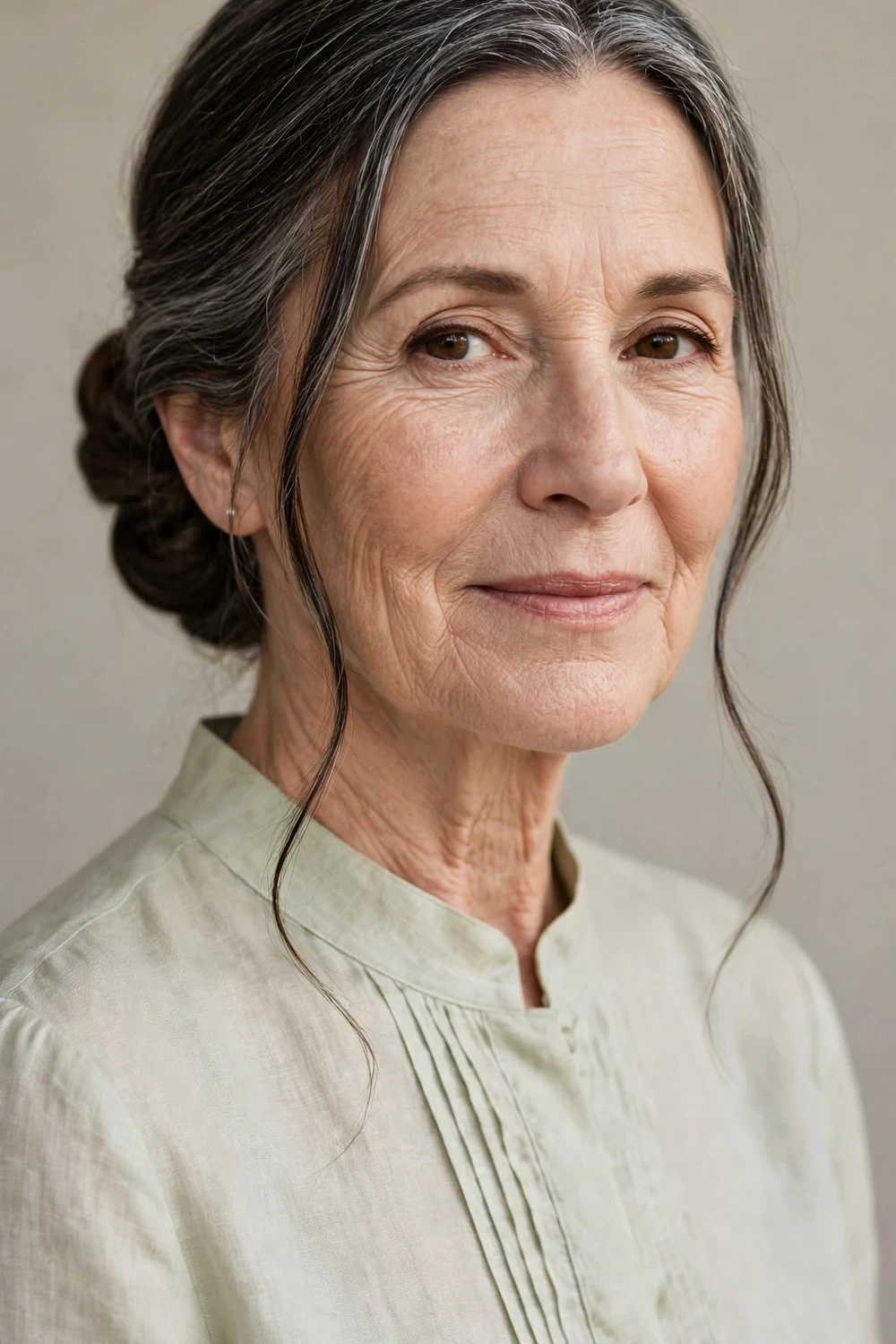 Older woman in her 60s with a classic low chignon at the nape of her neck