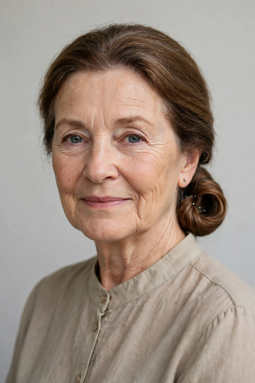 Older woman in her 60s with a low ponytail rolled under and pinned into an updo