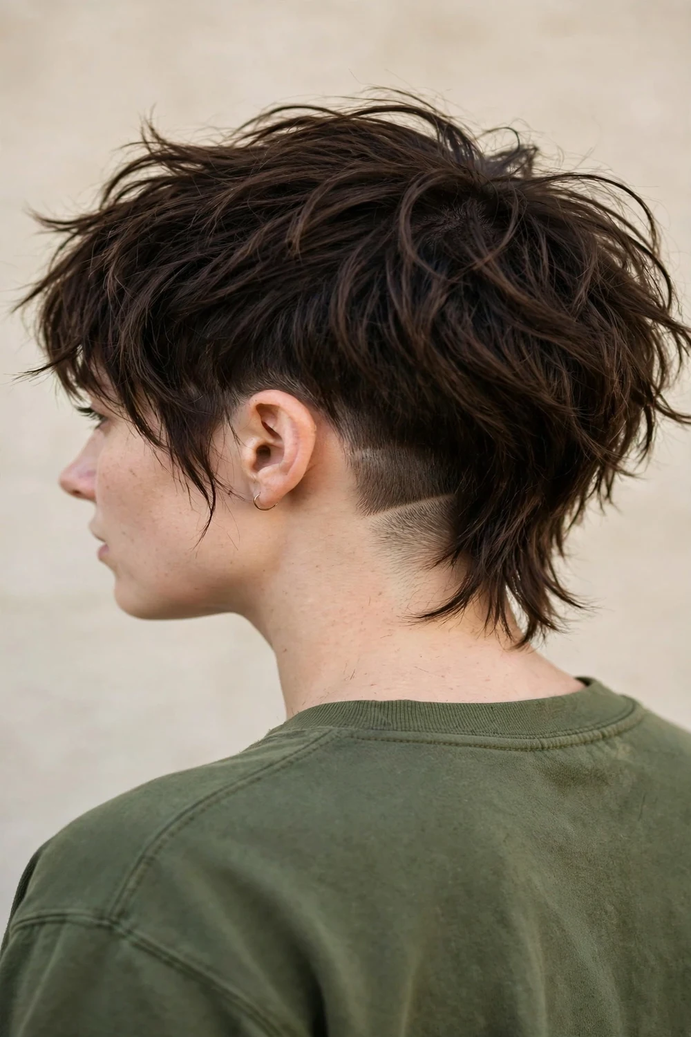 Woman with a wolf cut featuring a shaved undercut at the nape